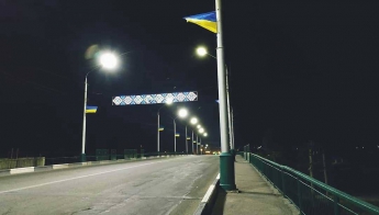 Ілюмінація в національному стилі вишиванки, що розвиваються прапори України в світлі яскравих ліхтарів прикрашають міст, підкреслюючи, що Мелітополь - це патріотичне серце України